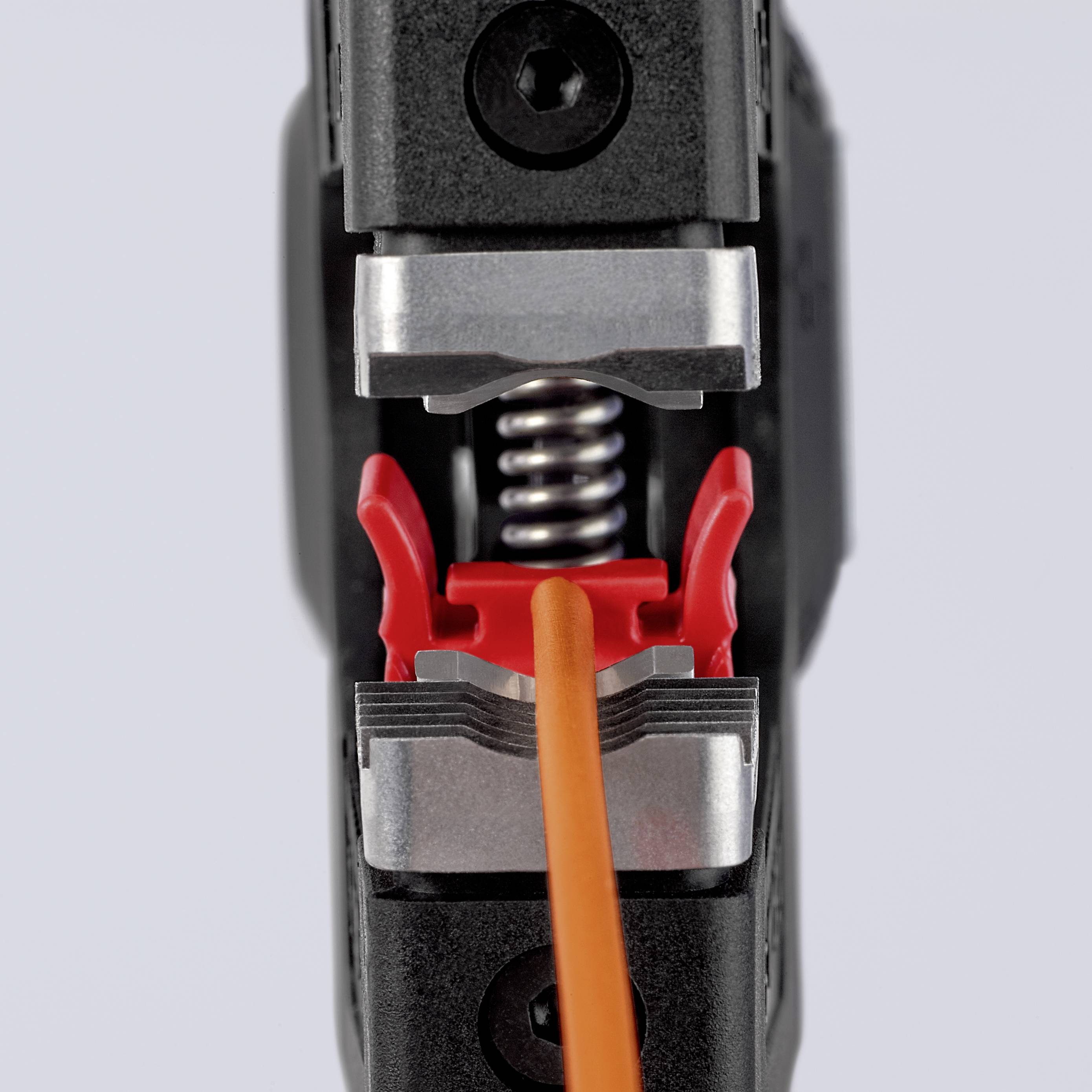 Nærbillede af et værktøj, der holder et orange kabel fast, med metalkomponenter og røde plastikdele.