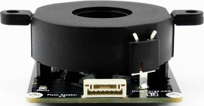 Et elektronisk komponent med en rund, sort overdækning og tilslutning på et trykt kredsløb, muligvis en piezo-højttaler.