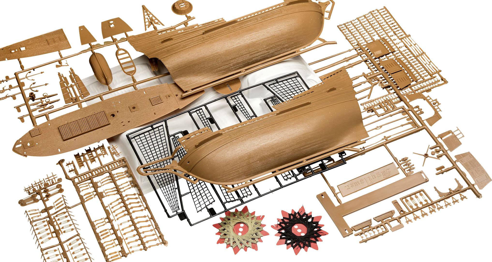Modelskibssæt bestående af brune og sorte plastikdele, herunder skrog og mindre komponenter.