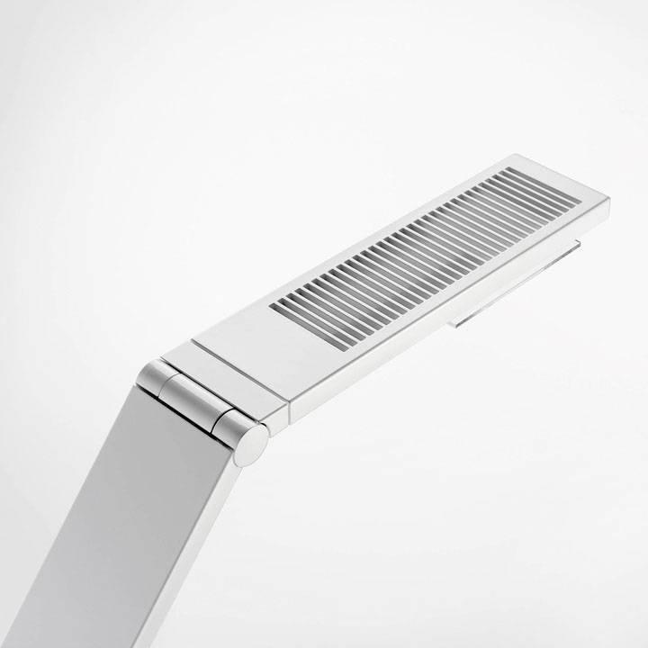 En moderne, sølvfarvet LED-bordlampe med en svingbar arm og rillet design, isoleret foran en hvid baggrund.