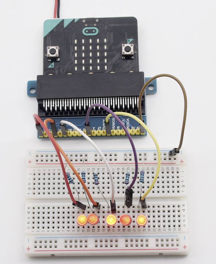 En mikrocontroller er forbundet med et breadboard. Fire LED'er lyser orange på boardet. Forskellige farvede kabler er tilsluttet.