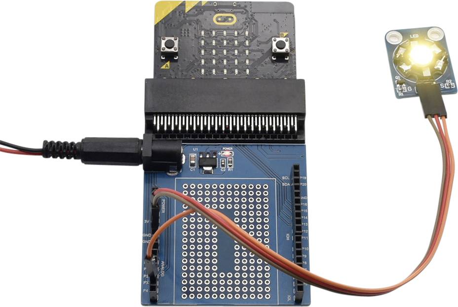 Et mikrocontroller-printplade med et tilsluttet LED-modul, der lyser kraftigt. Kabler forbinder printpladen med modulet.