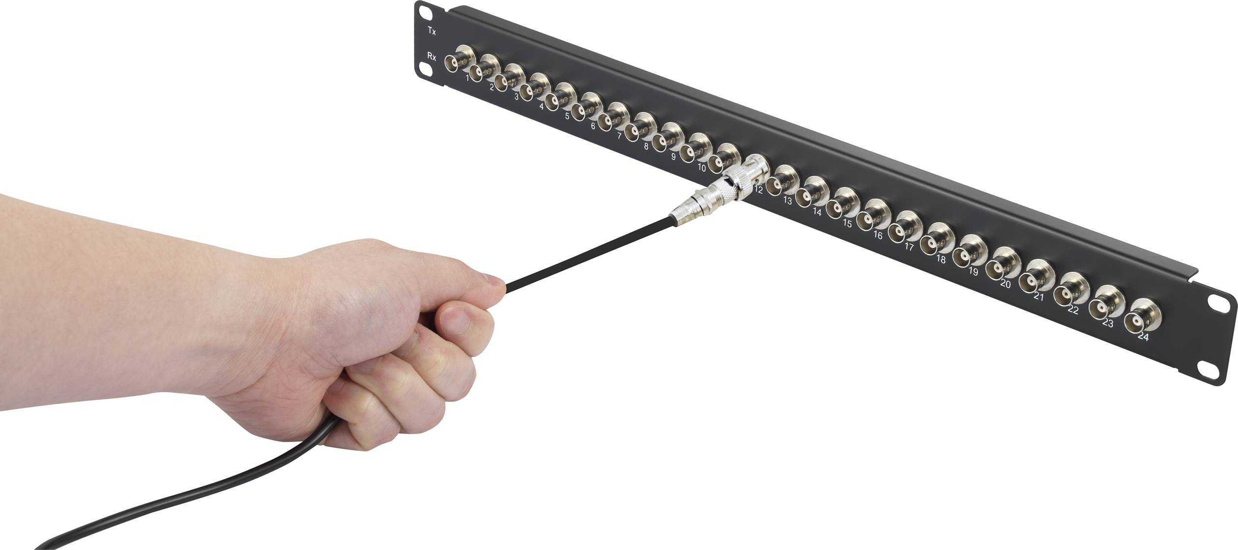 En hånd sætter et kabel i et stik på en rack-enhed med flere tilslutninger.