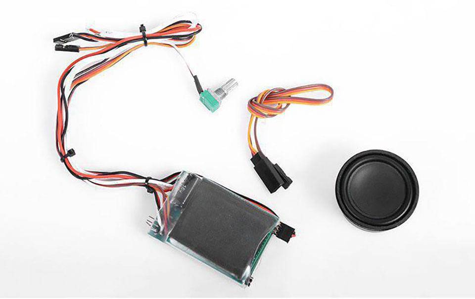 Elektronisk komponentssæt med kabler, en højttaler og et printpanel på hvid baggrund. Perfekt til DIY-projekter.