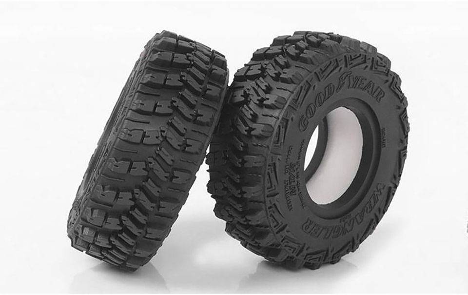 To sorte off-road-dæk står ved siden af hinanden. 'Goodyear Wrangler' er synligt på begge dæks side.