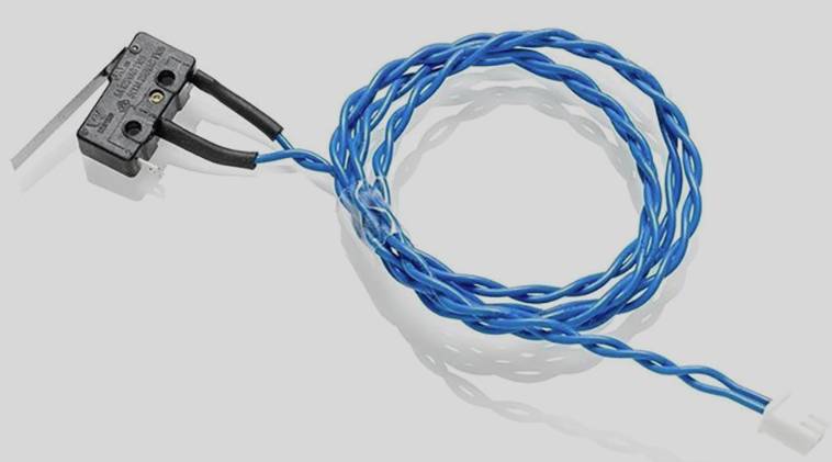 Mikrokontakt med blå drejet ledning på grå baggrund. Kontakten har to metalforbindelser og er egnet til elektriske forbindelser.
