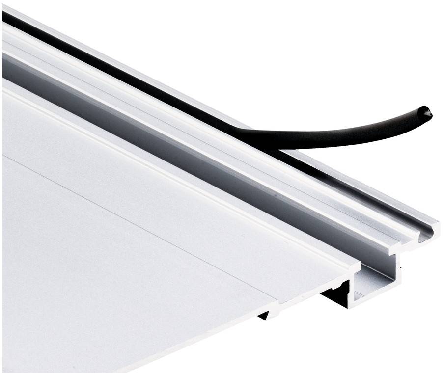 Sort kabel ført gennem en aluminiumslinær kanal over et hvidt panel, som viser en skjult kantbelysnings- eller triminstallation.