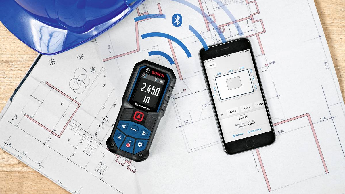 Smartphone og laserdistancemåler med teknisk tegning. Afstand vist på enheden: 2,450 m. Bluetooth-symbol synligt.