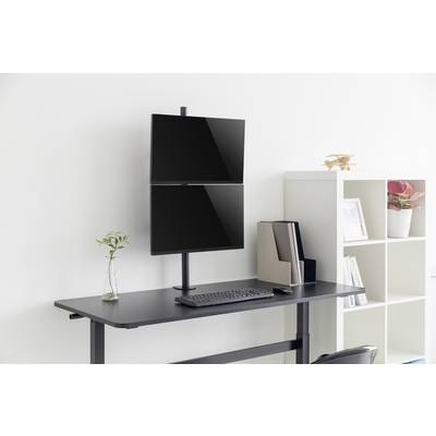 Et elegant stående skrivebord med to vertikale skærme, tastatur, mus og en lille plantekrukke ved siden af foran en lys baggrund.