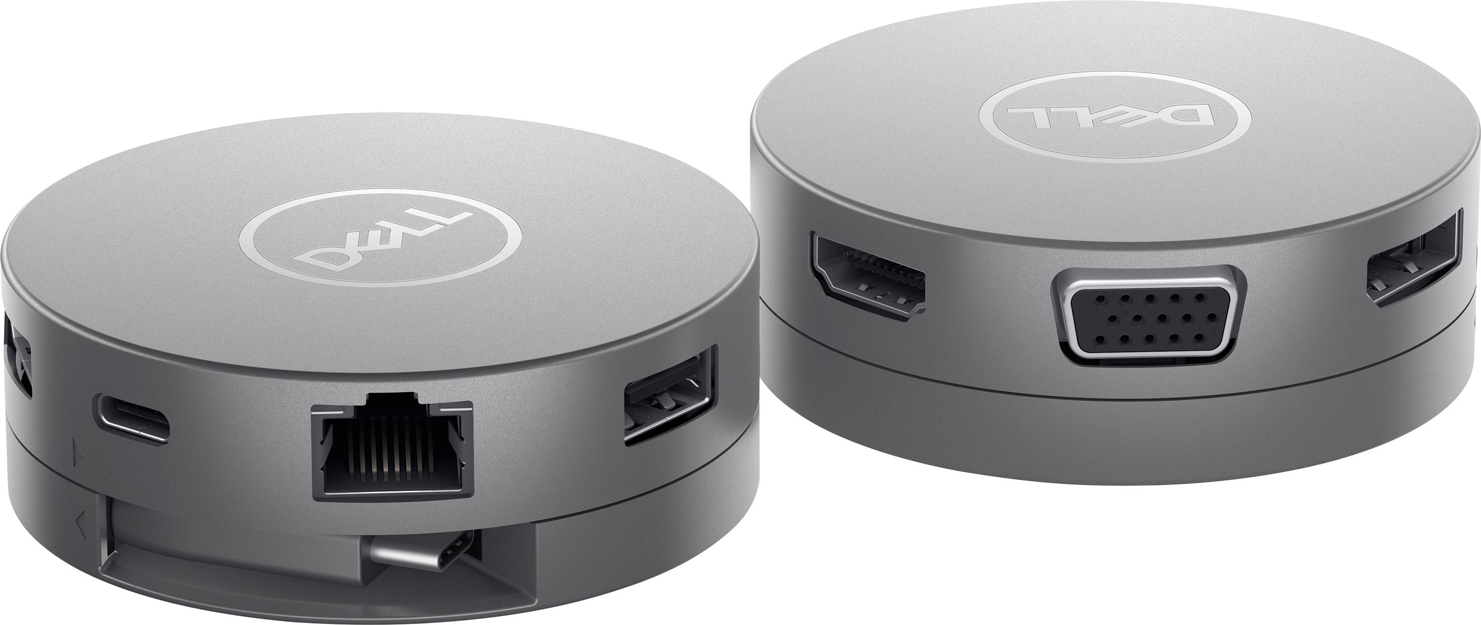 To elektroniske, runde sølvfarvede adaptere med forskellige tilslutninger som HDMI, USB og VGA, placeret på en hvid overflade.
