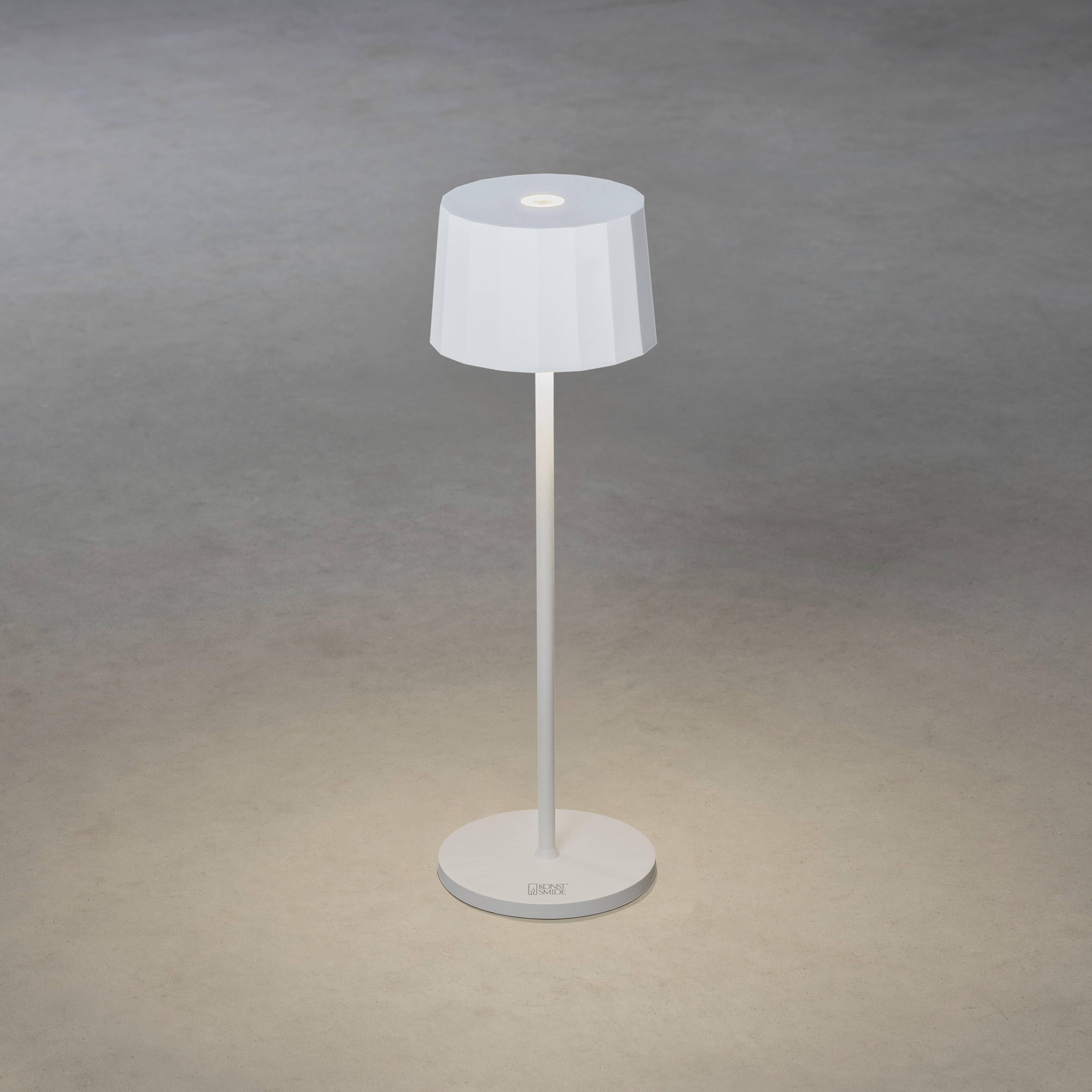 Et moderne, hvidt gulvstativ med lampe på grå gulv, der spreder varmt lys i et minimalistisk indrettet rum.