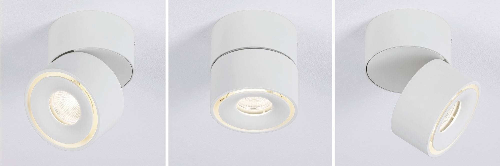 Tre moderne, hvide loftslamper i cylinderform. Hver lampe er indstillet i en anden retning.