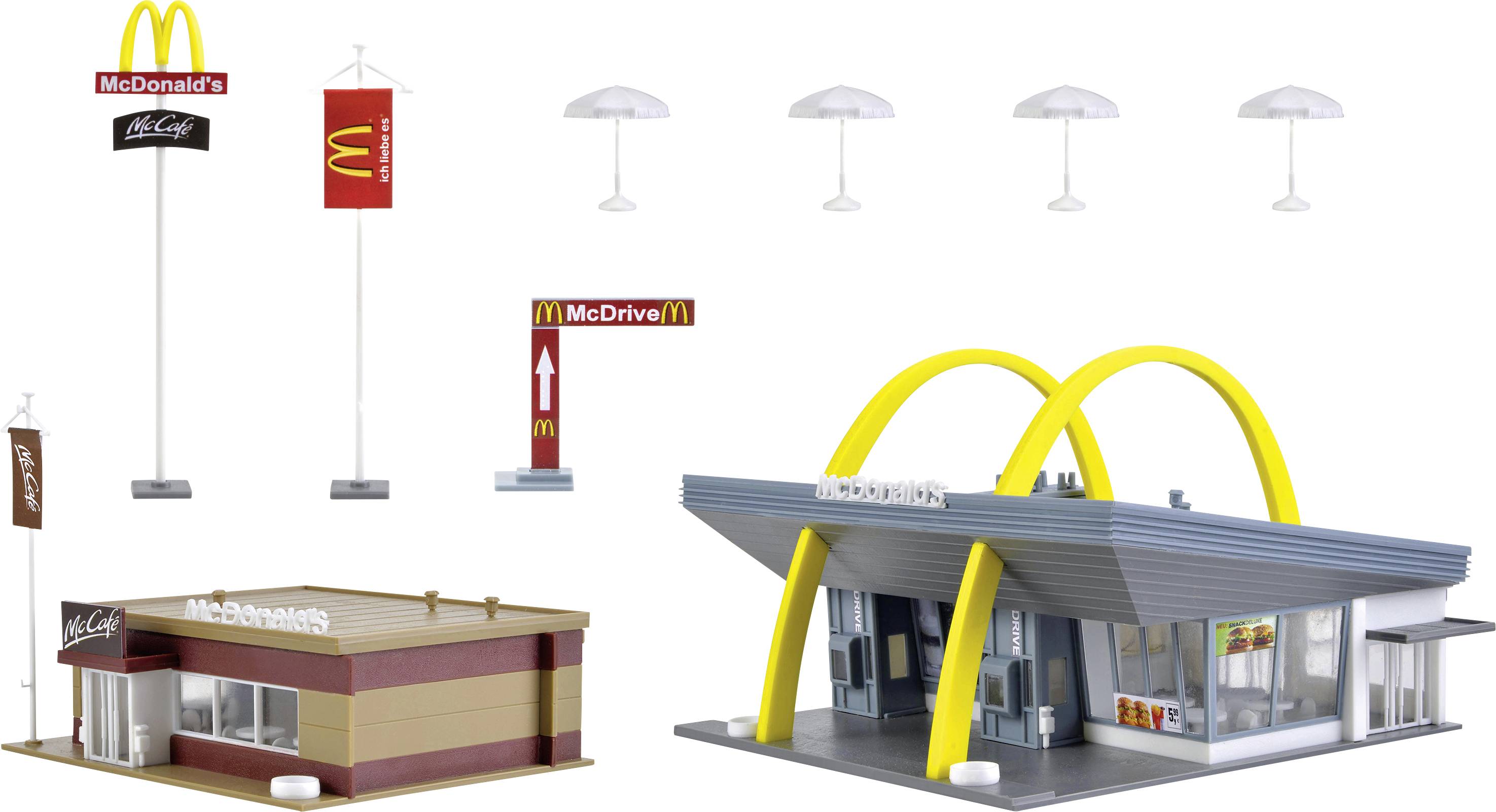 En model af to McDonald's-bygninger: en i retro-stil med gule buer og en i en mere moderne stil, plus skilte.
