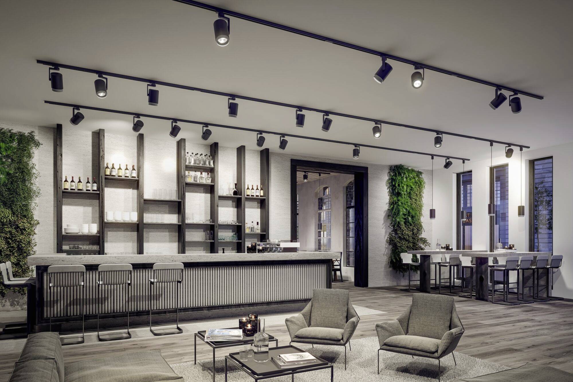 Et moderne indrettet stue med bar. Siddeområde med sofaer og bord i forgrunden. Plantevægge og høje vinduer i baggrunden.