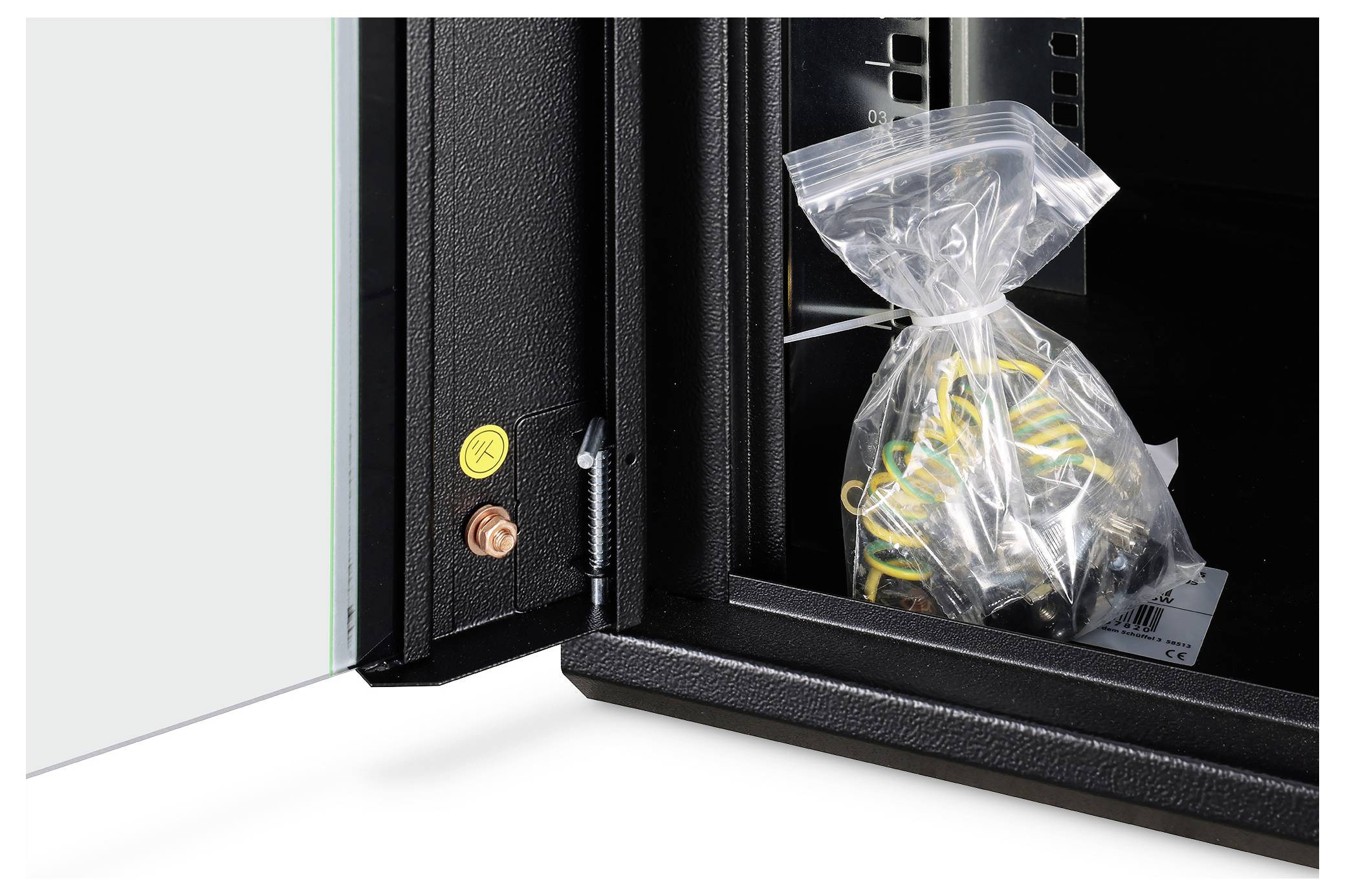 'Pose med skruer og forbindelsesstykker inde i et åbent sort skab, som fremhæver indvendig emballage og opbevaringsløsninger.'