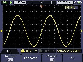 Oscilloskopskærmen viser en gul sinusbølge med en frekvens på 999,9 Hz og en spænding på 12,0 V på kanal 1.
