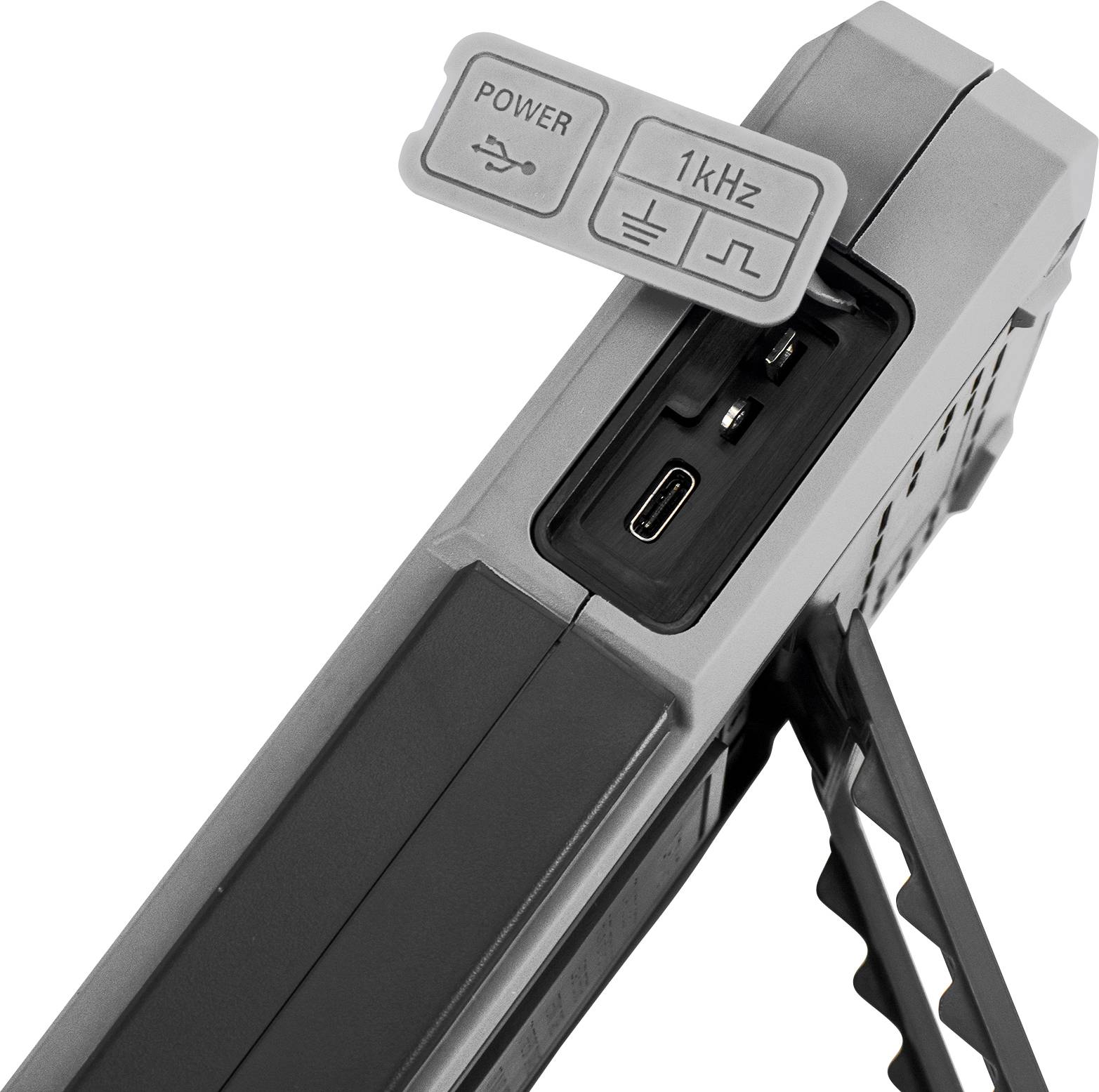 Elektronisk enhed med USB-porte, en strømstik og en 1 kHz-kontakt. Sidestøtte for stabilitet.