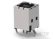 En metallisk elektrisk komponent, sandsynligvis en kontakt eller stikforbindelse, med fire benstik synlige forneden.