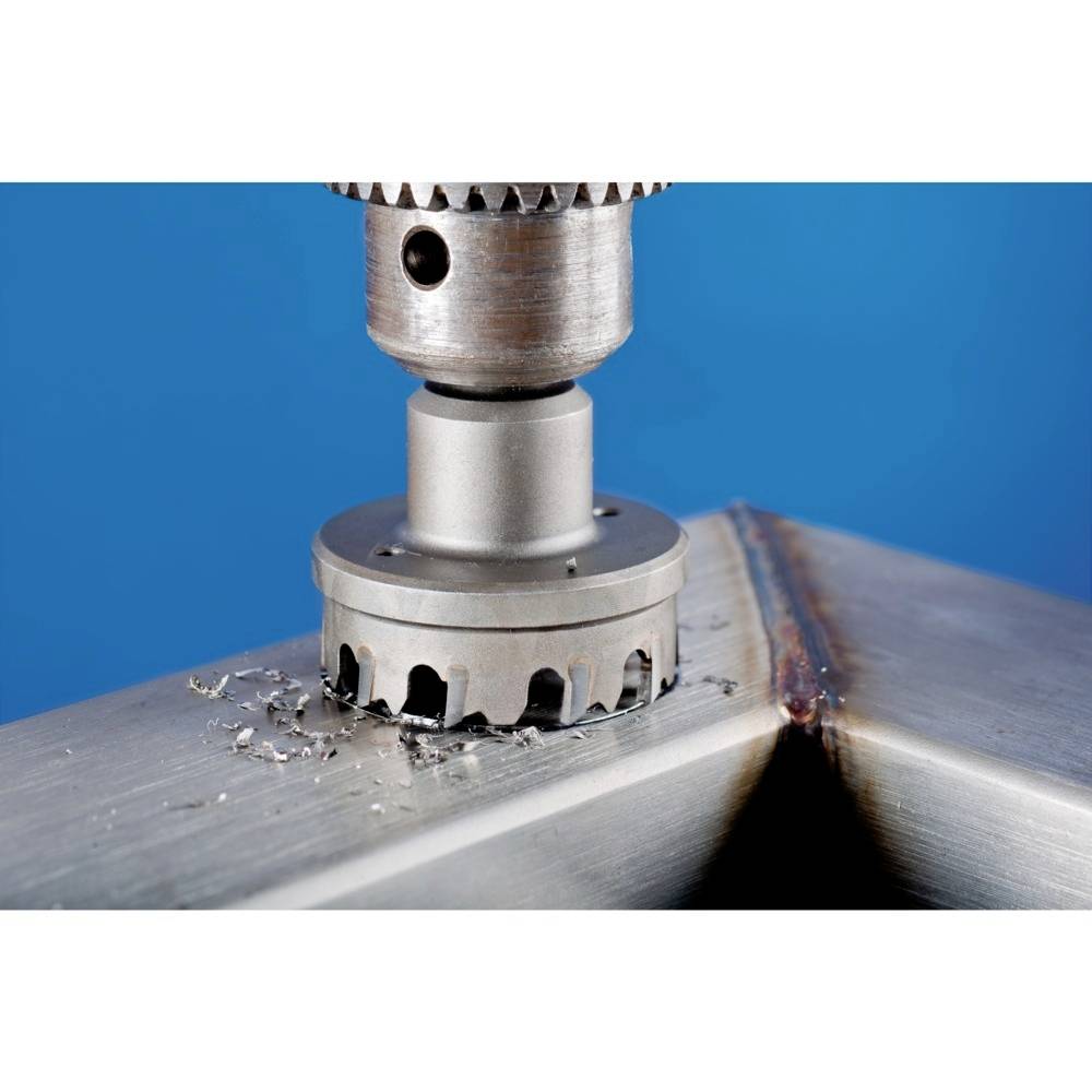 En bor bearbejder en metallisk overflade og skaber glatte kanter. Baggrunden er blå, og spåner er synlige.