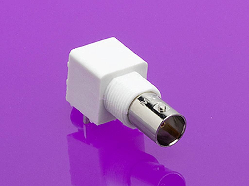 En hvid, rektangulær adapter med metalstik på en lyserød baggrund. Adapteren har et BNC-stik design.