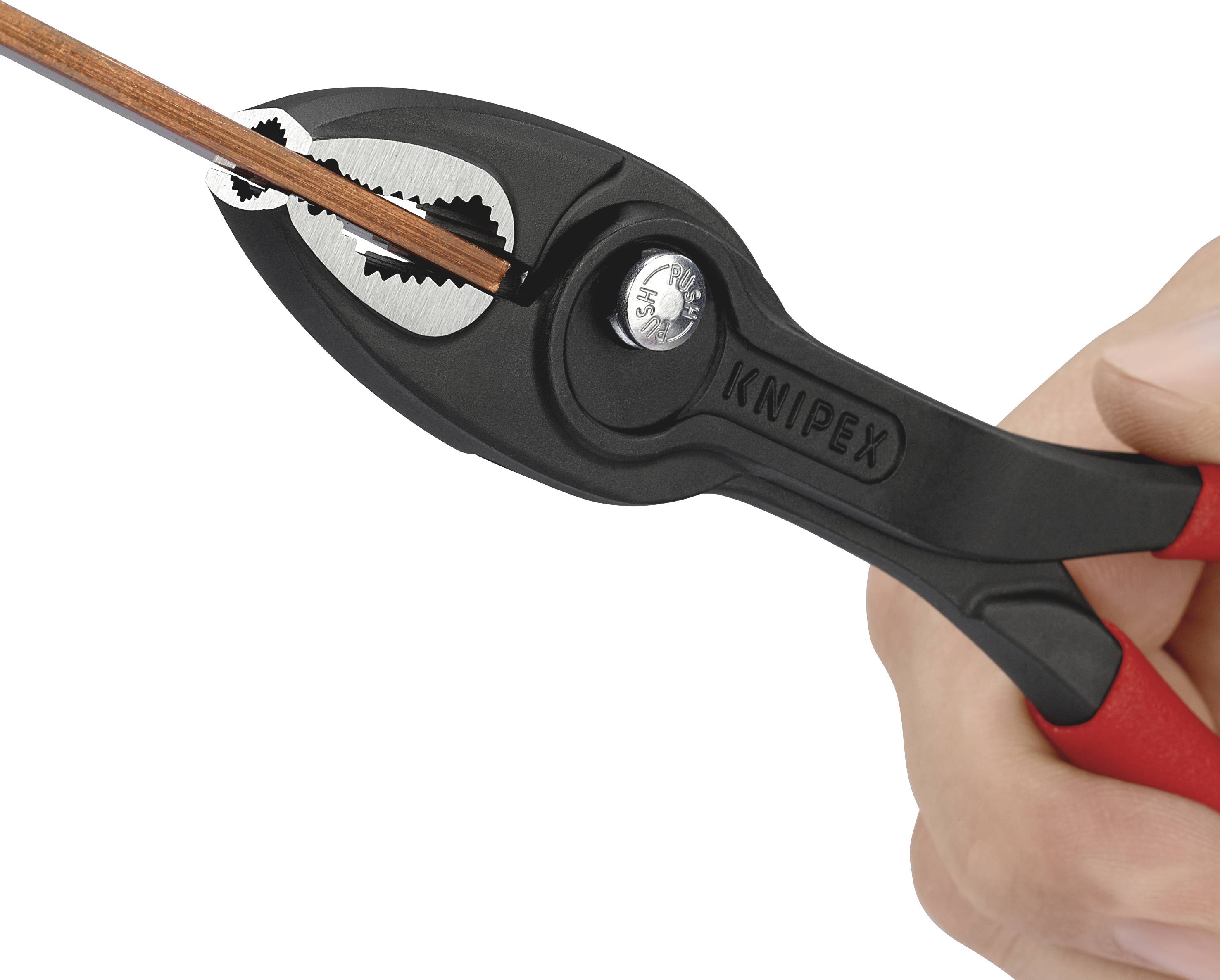 En sort tang klipper en tynd tråd. En hånd holder tangen, som er lavet af plast og metal.