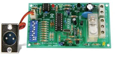 Et grønt printpladekort med flere elektroniske komponenter, herunder modstande, kondensatorer og en IC-chip, forbundet med en XLR-stik.