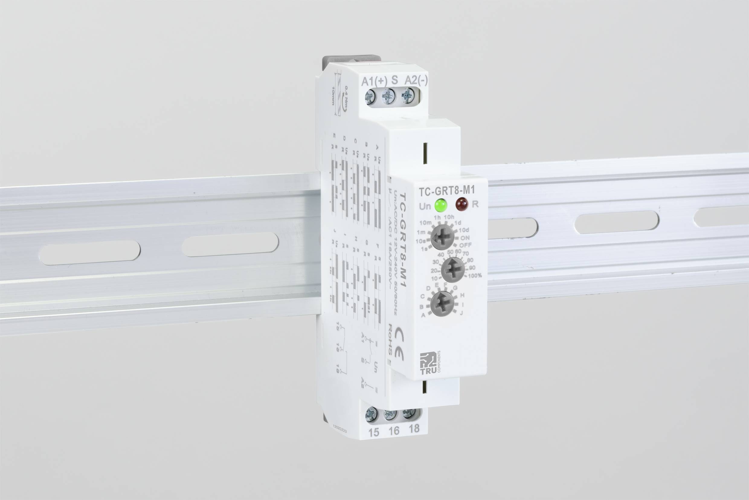 Et elektronisk apparat med drejepotentiometre er monteret på en DIN-skinne. Det har LED-displays og tekniske mærkninger.