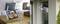Et tablet på et træbord viser kamerabilleder af indendørsrum. Udenfor er et sikkerhedskamera monteret på husets ydervæg.