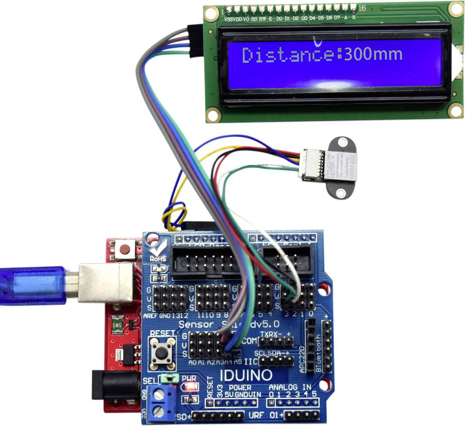 Arduino-sæt med tilsluttet ultralydssensor og LCD-display, som viser 'Distance: 300mm'. Viser sensoraflæsning i realtid.