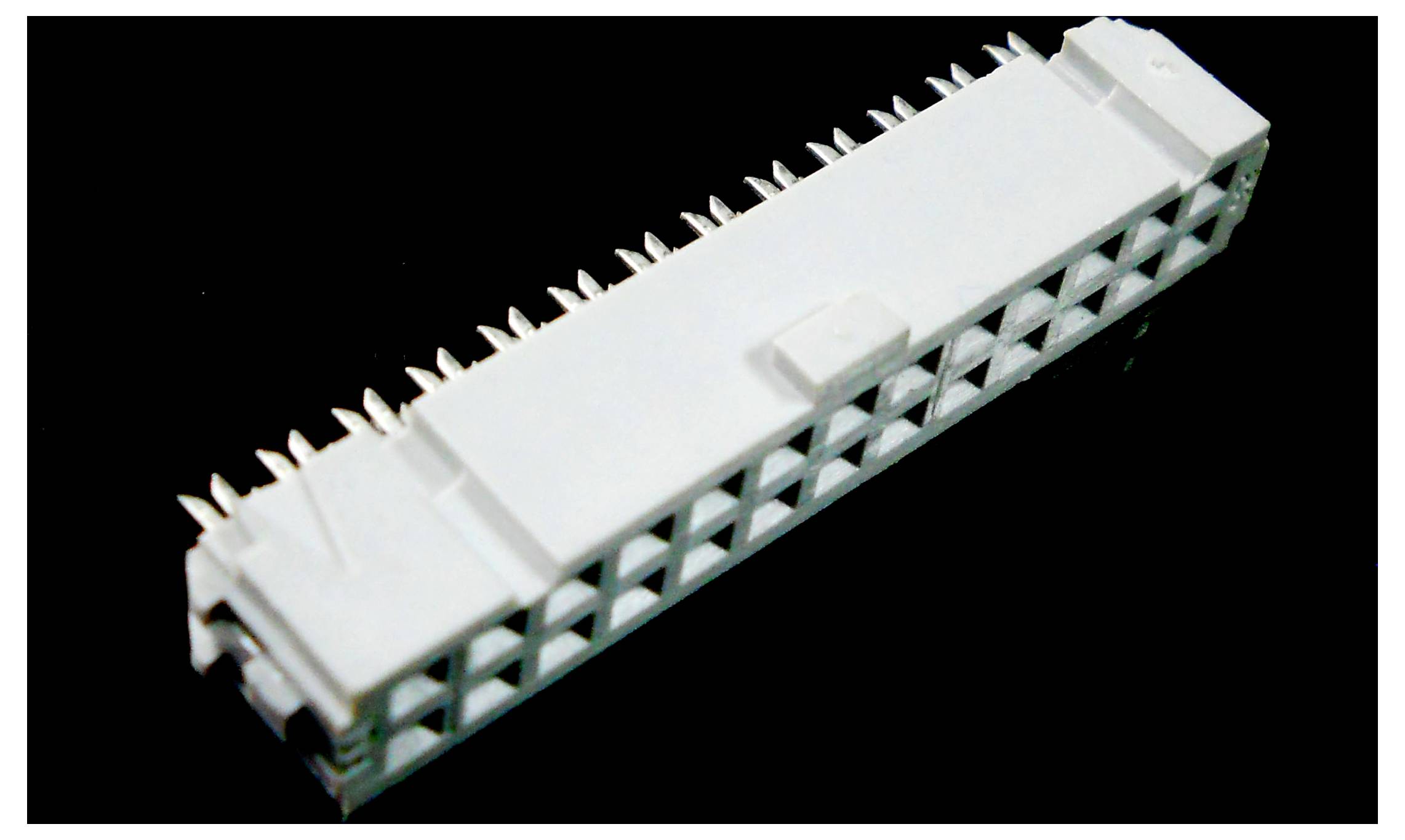 En rektangulær hvid elektrisk stik med flere ben, der stikker ud fra undersiden, designet til elektroniske eller computerhardware-grænseflader.