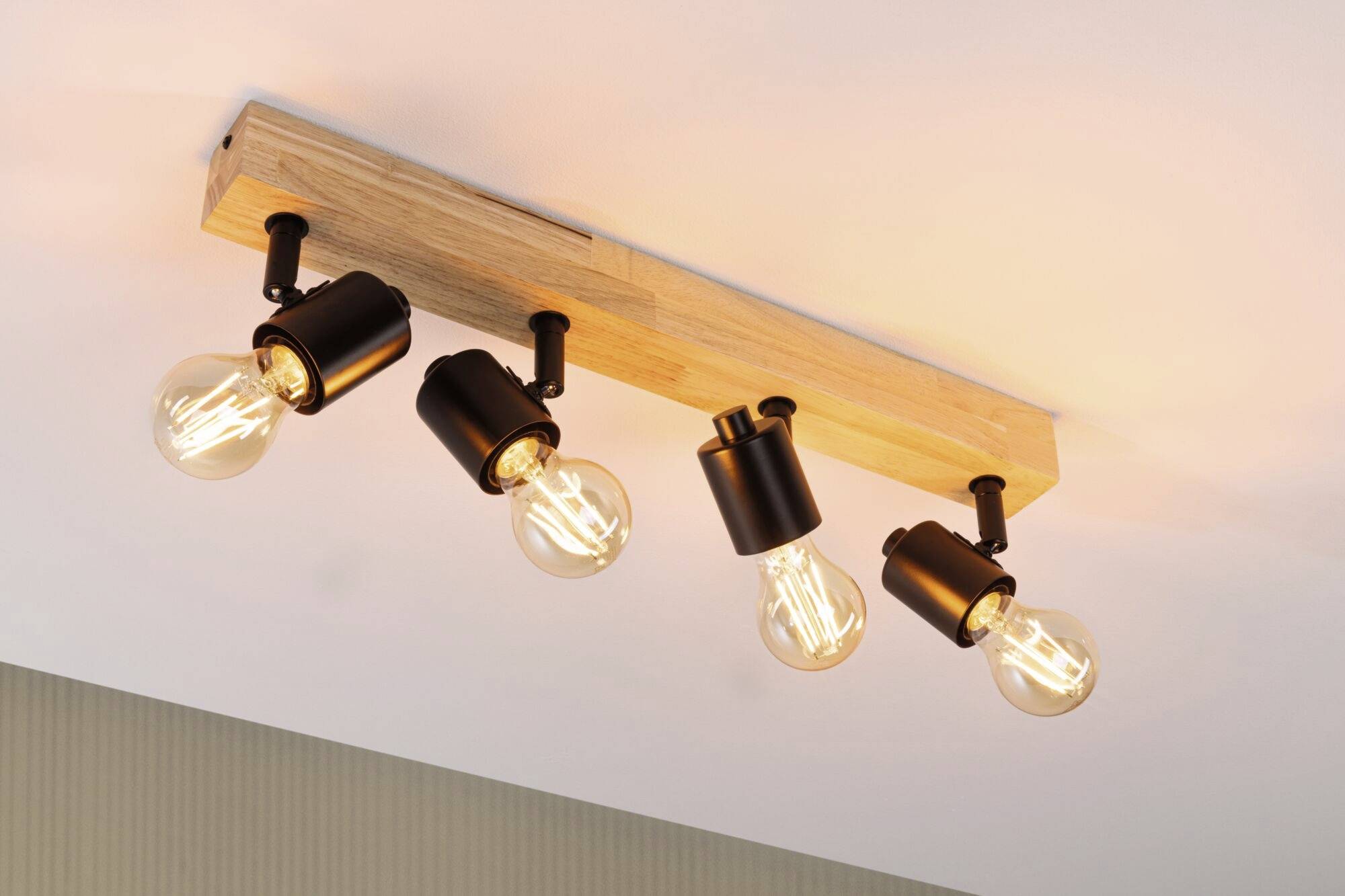Firedobbelt loftlampe med træmontering, runde sorte fatninger og varmt hvide glødepærer, monteret på hvid loft.