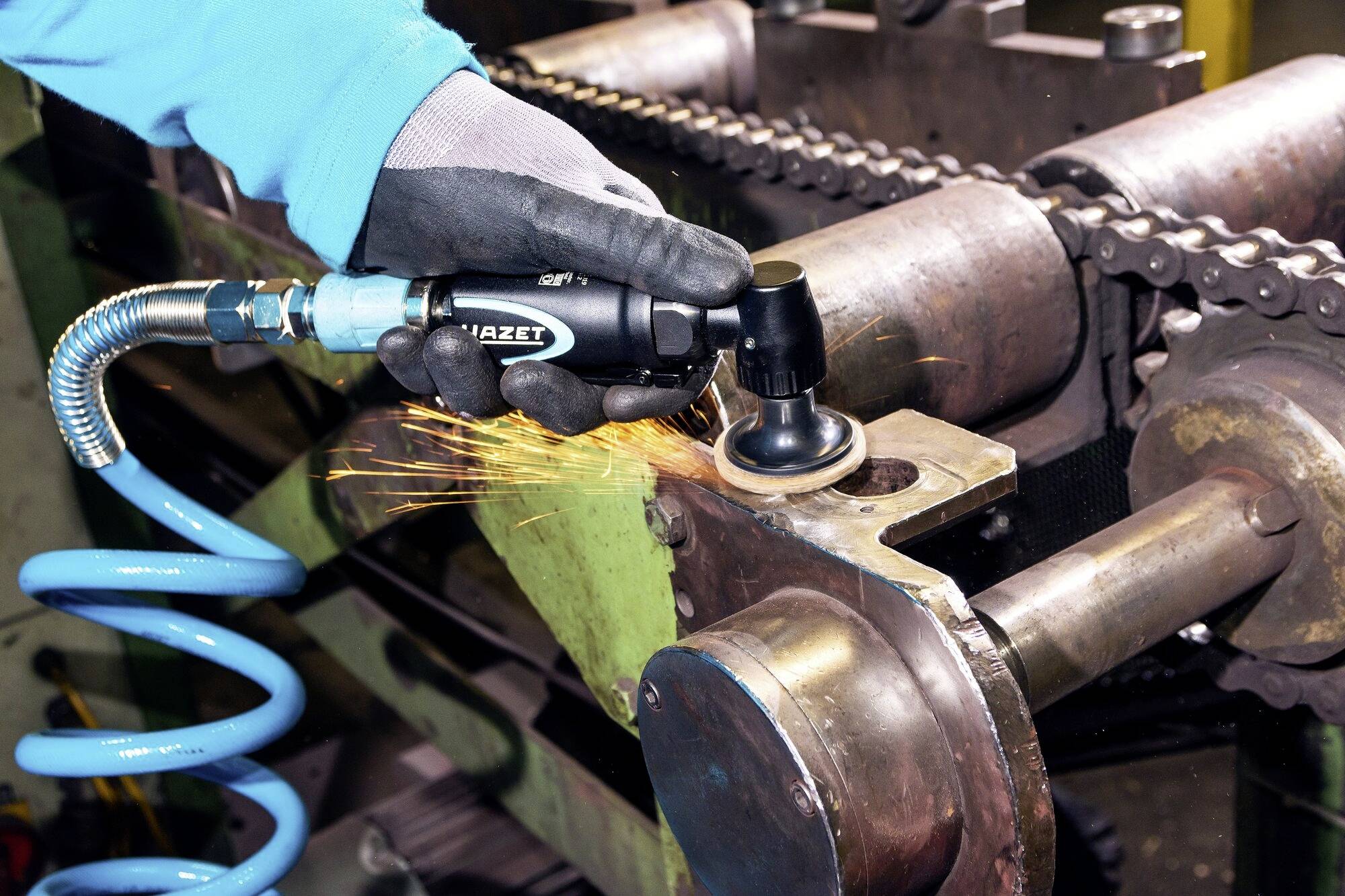 En person bruger en vinkelsliber til at bearbejde metal. Gnister sprøjter, mens værktøjet rammer metaloverfladen.