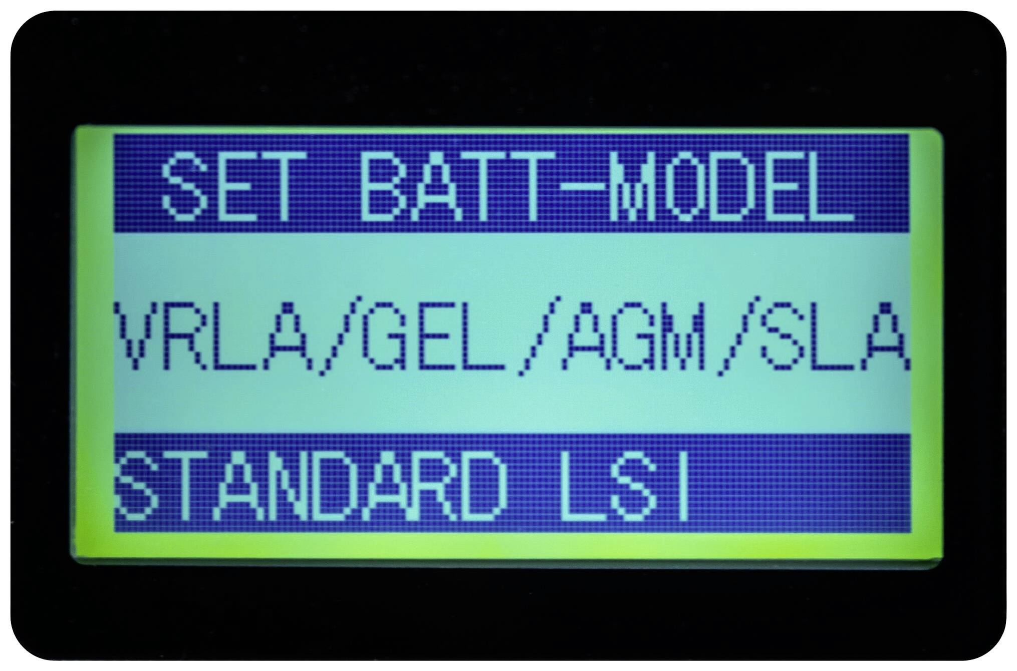 Et billede af et elektronisk display med tekst: 'INDSTIL BATTERI-MODEL VRLA/GEL/AGM/SLA STANDARD LSI'. Viser batterikonfigurationsindstillinger.