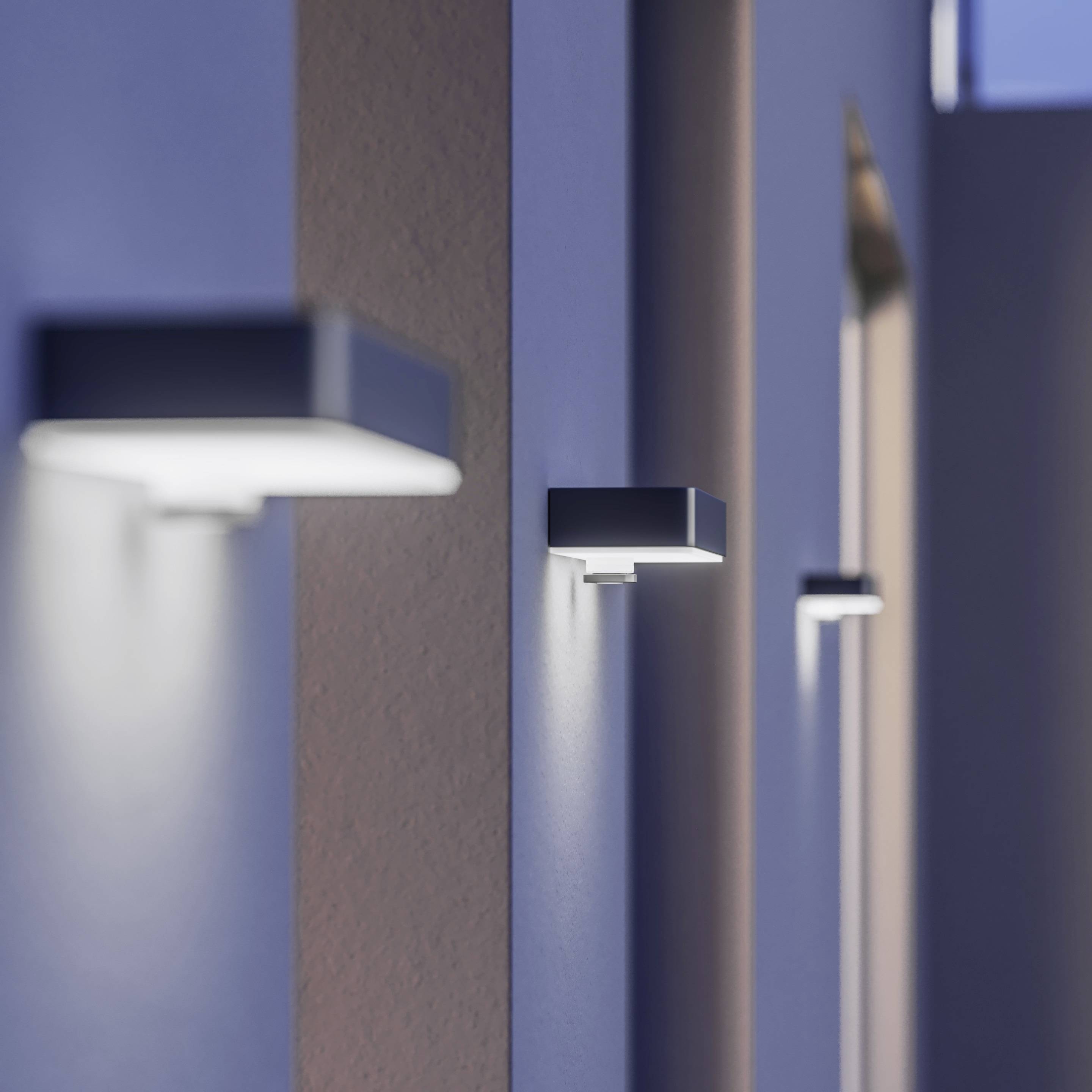 Ydervæg med moderne rektangulære armaturer, der spreder blødt lys i skumringen og understreger en samtidig arkitektur.