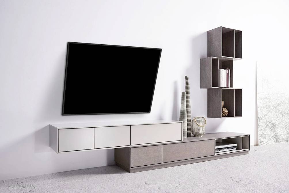 Moderne stue med vægmonteret TV, minimalistisk reol og skulptur på hvid baggrund. Enkelt, elegant design.