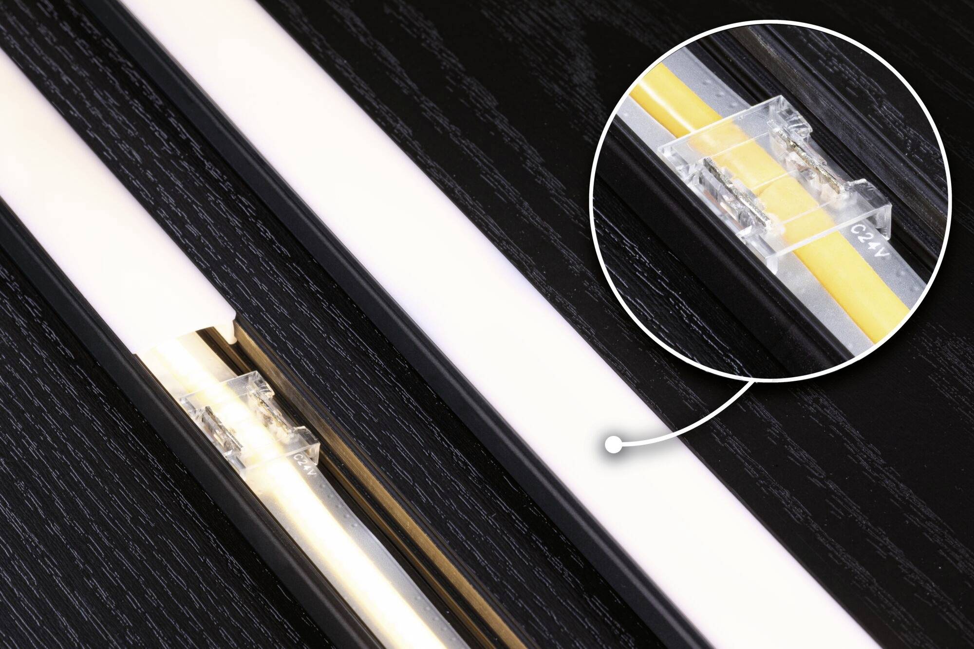 En LED-stribe i nærbillede viser et transparent forbindelseselement i en cirkulær forstørrelse.