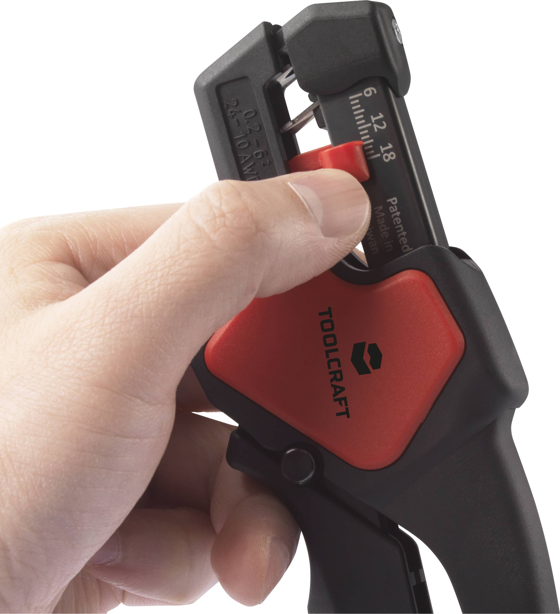 En hånd holder en rød og sort afisoleringstang fra mærket Toolcraft; skaleret fra 6 til 18.
