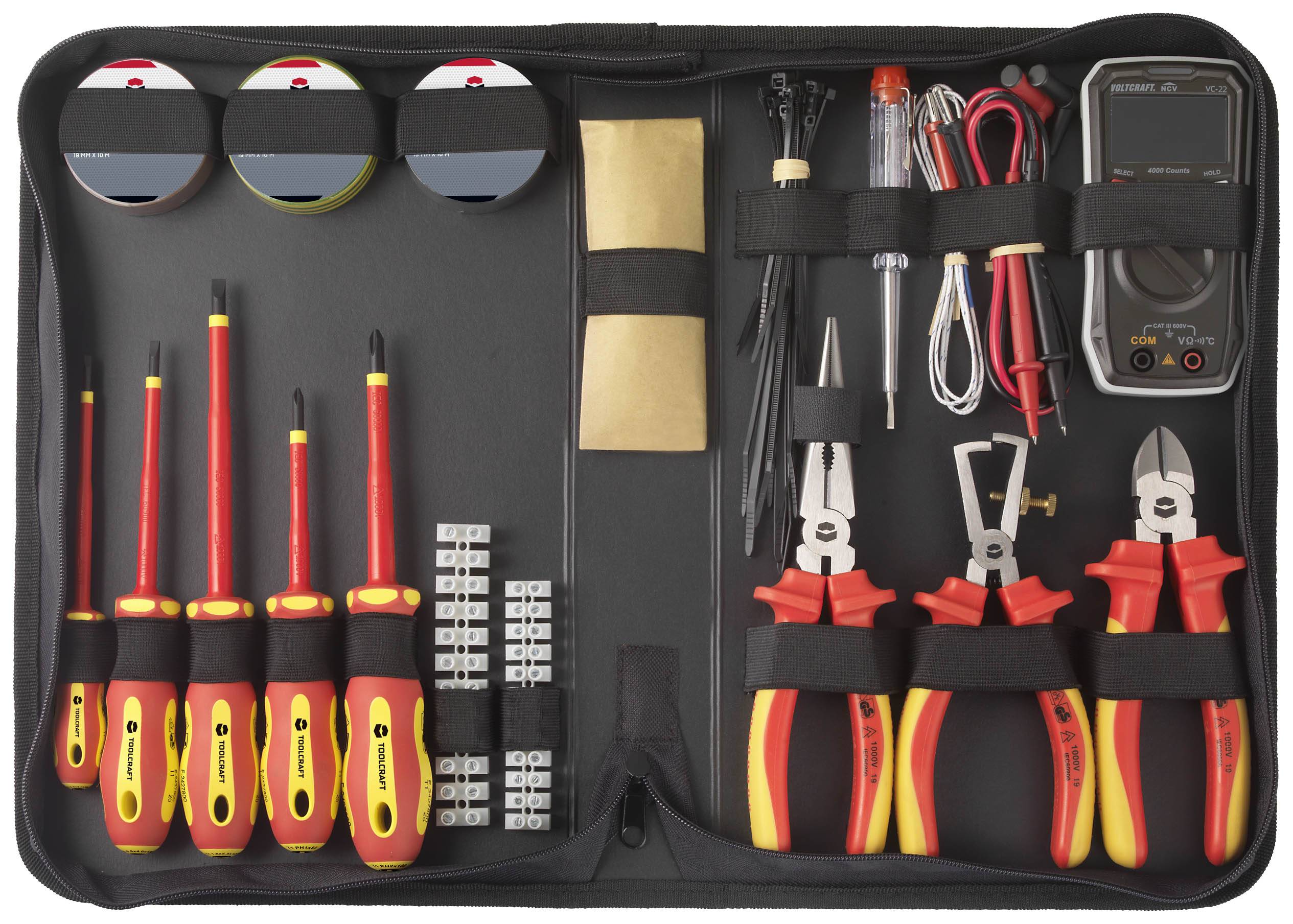 Værktøjssæt med skruetrækkere, tænger, kabelbindere og et digitalt multimeter, arrangeret i en åben bæretaske.