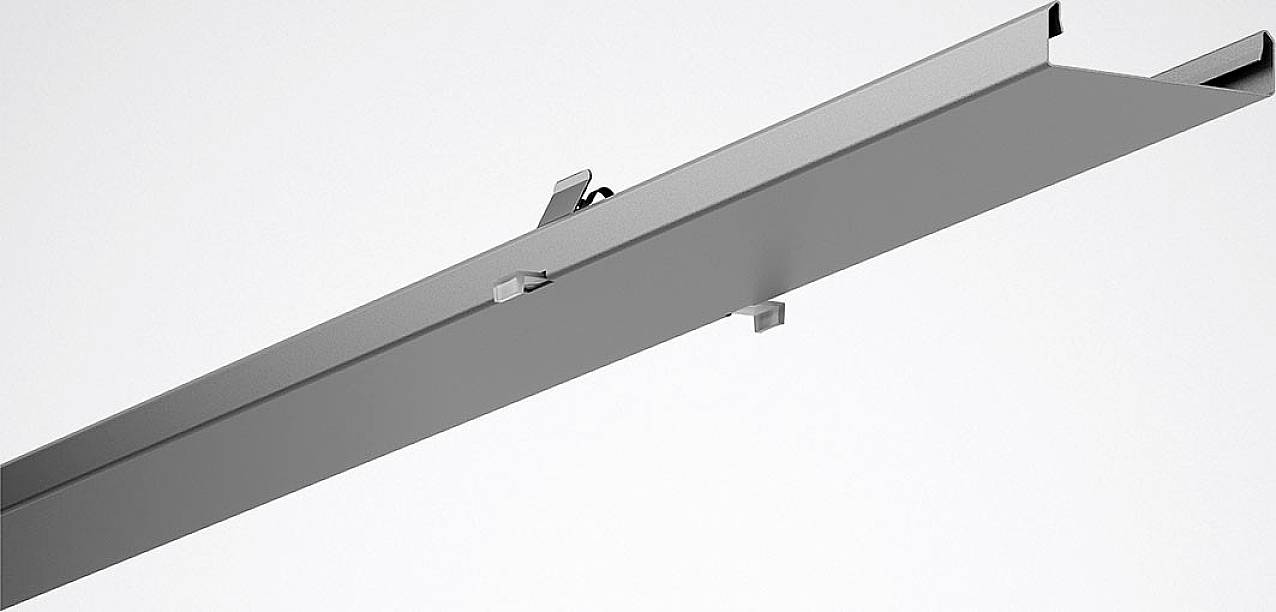 Et gråt, lineært metalstykke med en krog på indersiden; sandsynligvis en del af et belysningssystem eller en reolbærer.