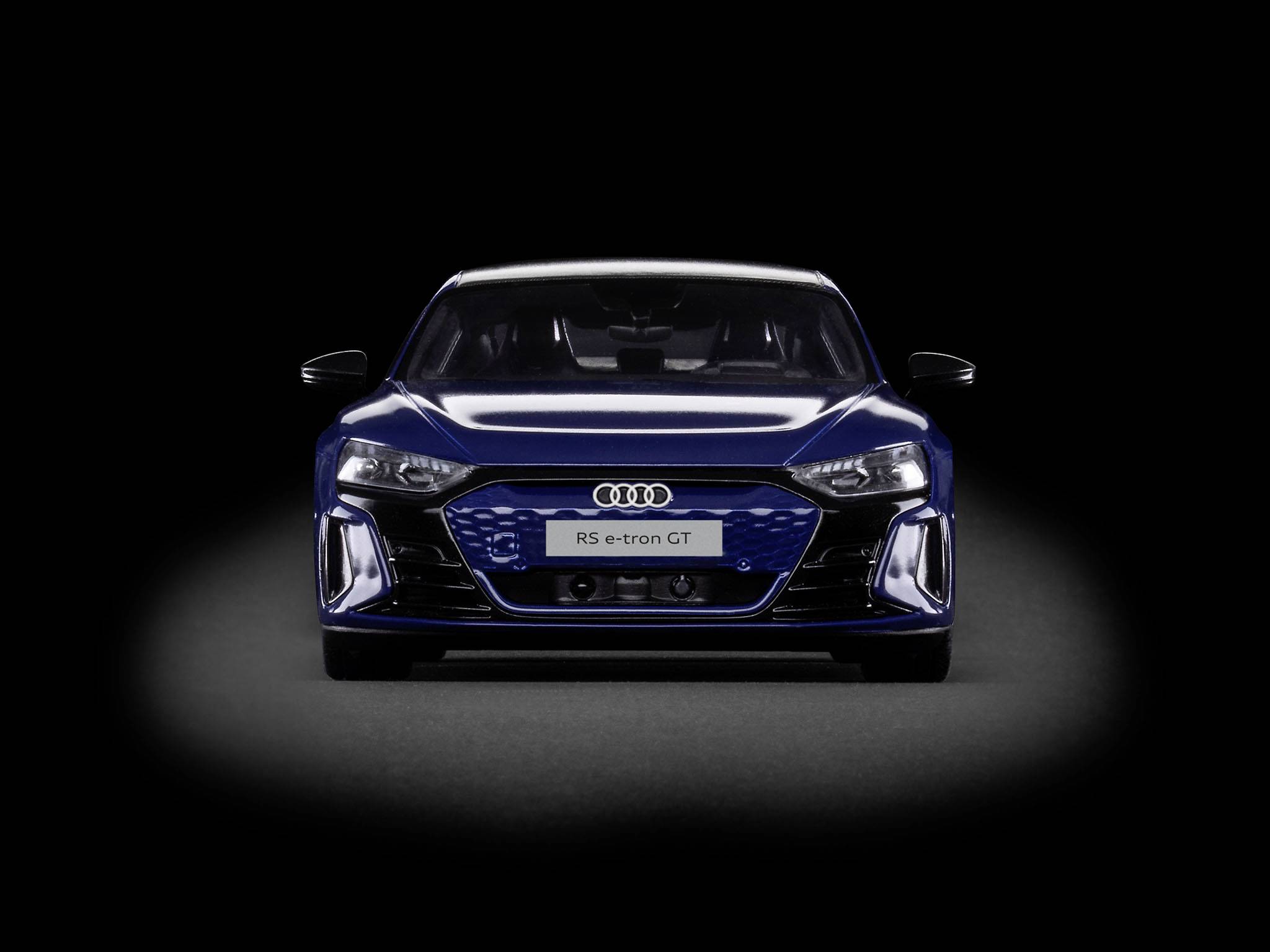 Audi RS e-tron GT i mørkeblå, set forfra mod sort baggrund, viser den moderne, sportslige design af elbilen.