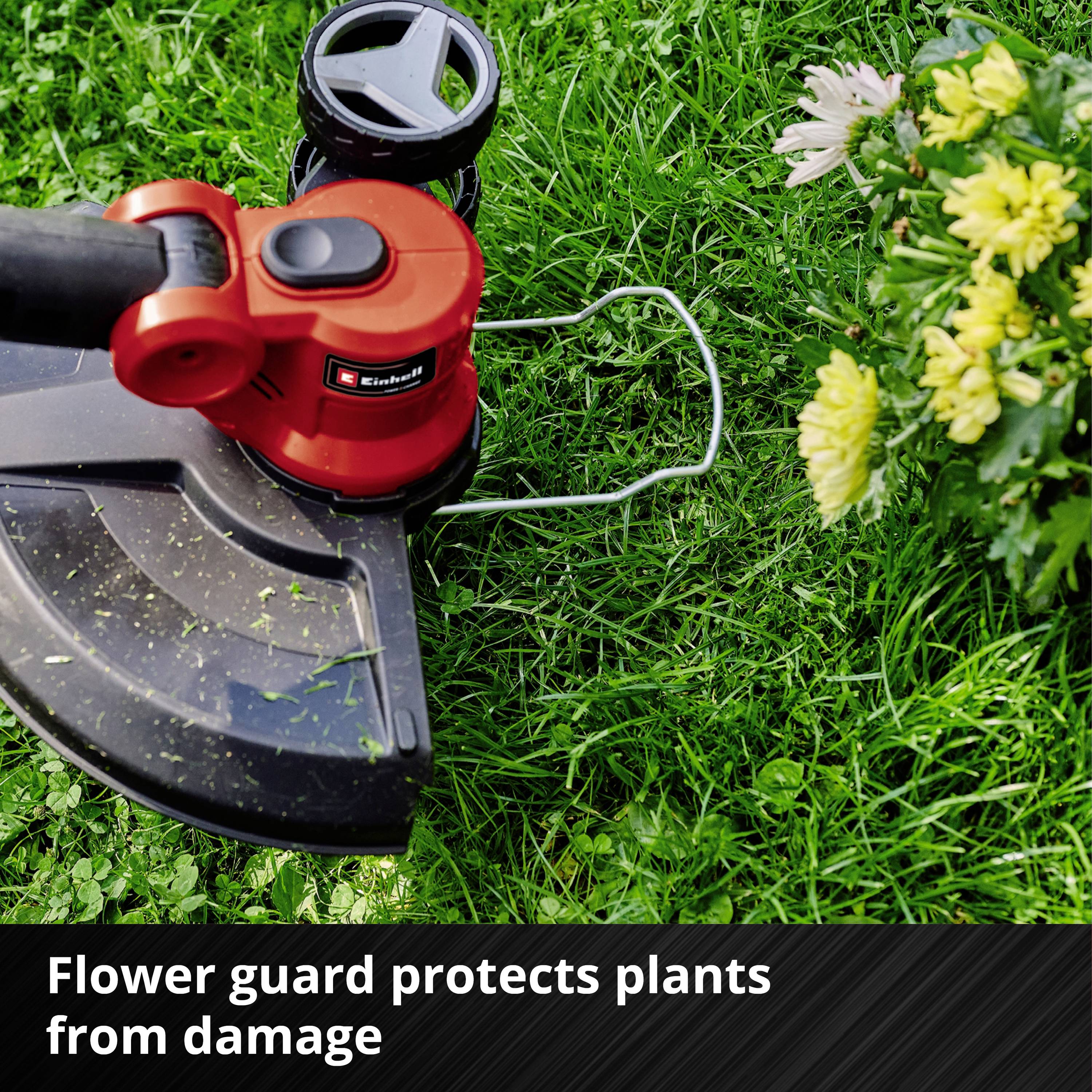 En plæneklipper med 'Flowerguard' beskyttelse arbejder i en have, omgivet af grønt græs og gule blomster.