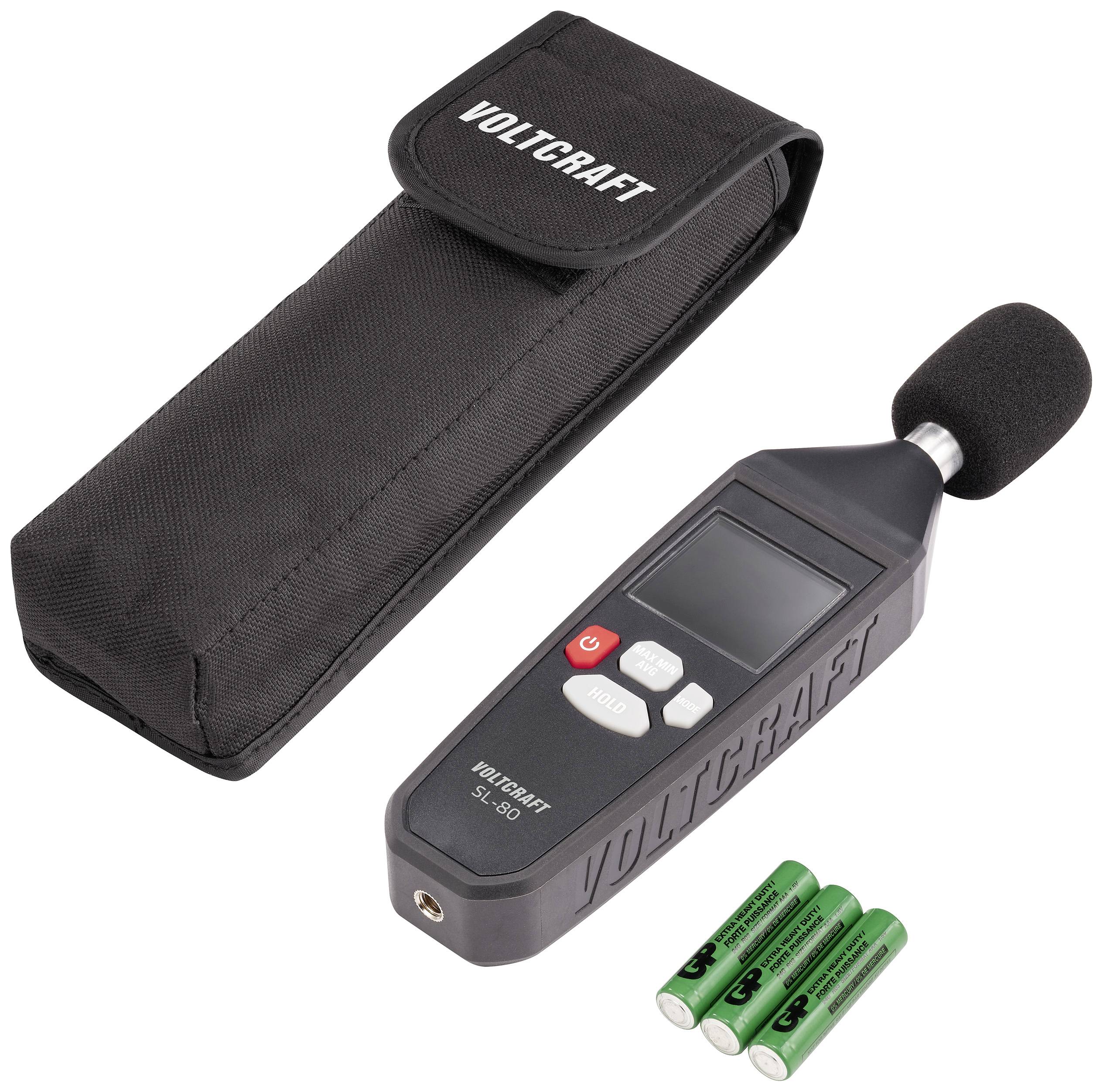 Støjmåler med display, ved siden af en sort etui og tre batterier. Egnet til måling af støjniveauer.