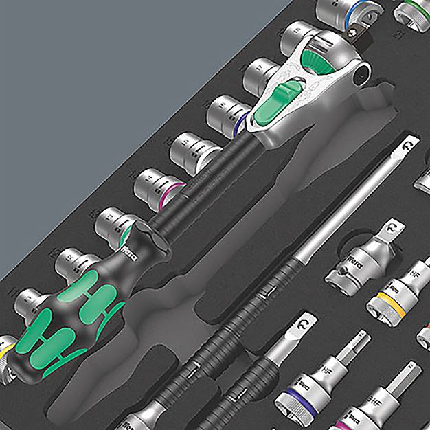 Et sæt værktøj i en skumholder omfatter forskellige topnøgler, en skralde og skruetrækkere. Værktøjet har sorte og grønne håndtag.