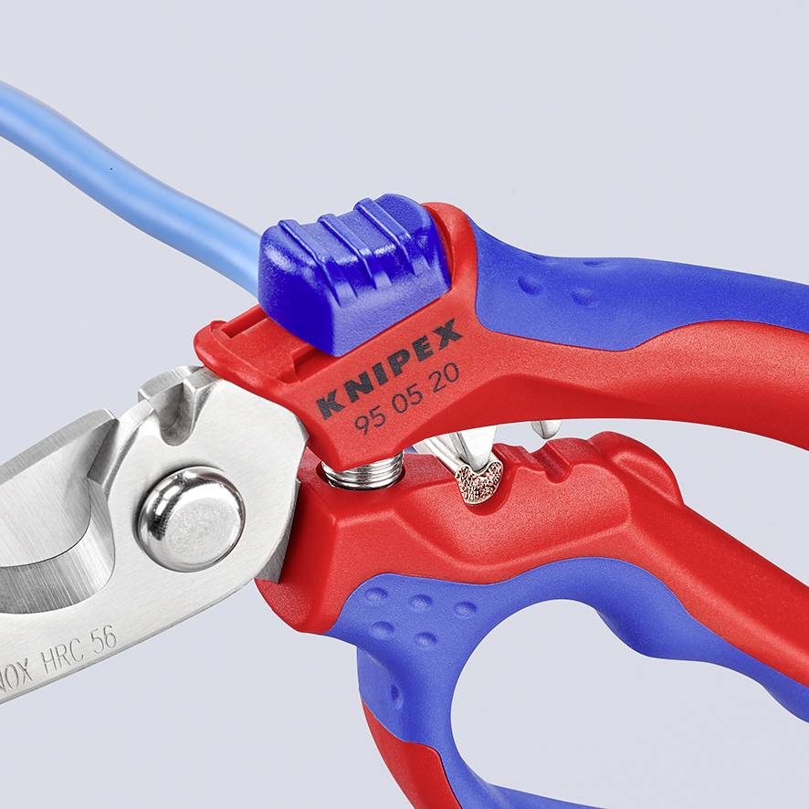 En elektriker-tang med rødt og blåt greb klipper et blåt kabel. Påskriften 'Knipex' er på grebet.