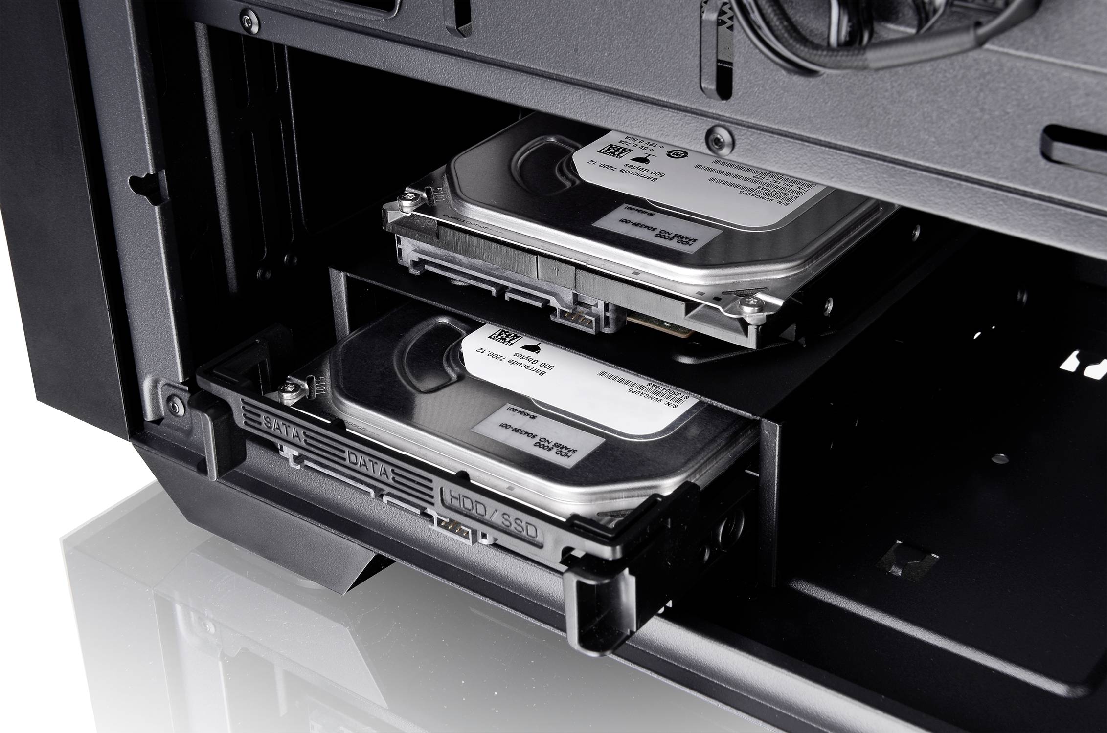 To parts af en harddisk er installeret i et computerkabinet. Den øverste harddisk er delvist synlig, den nederste er trukket ud.