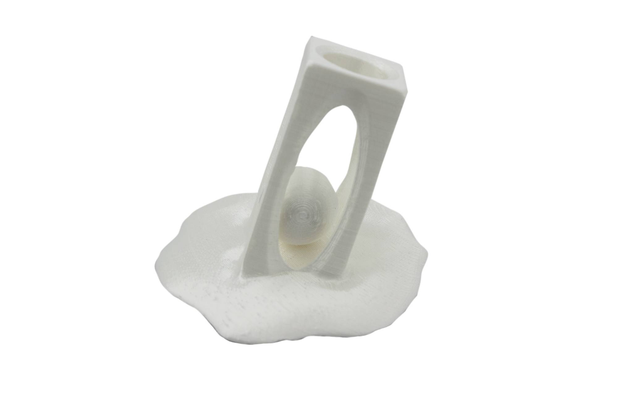 En hvid 3D-printet holder med en oval åbning, hvorigennem en hvid kugle er synlig, står på et bølget fundament.