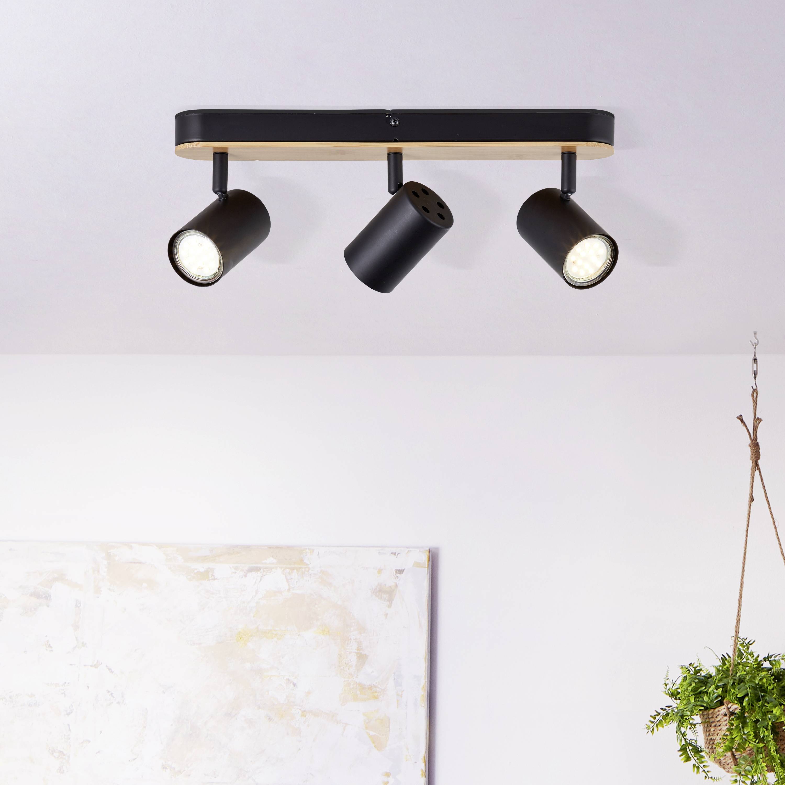 Moderne, sort loftslampe med tre justerbare spots, som er ligeligt monteret på loftet.