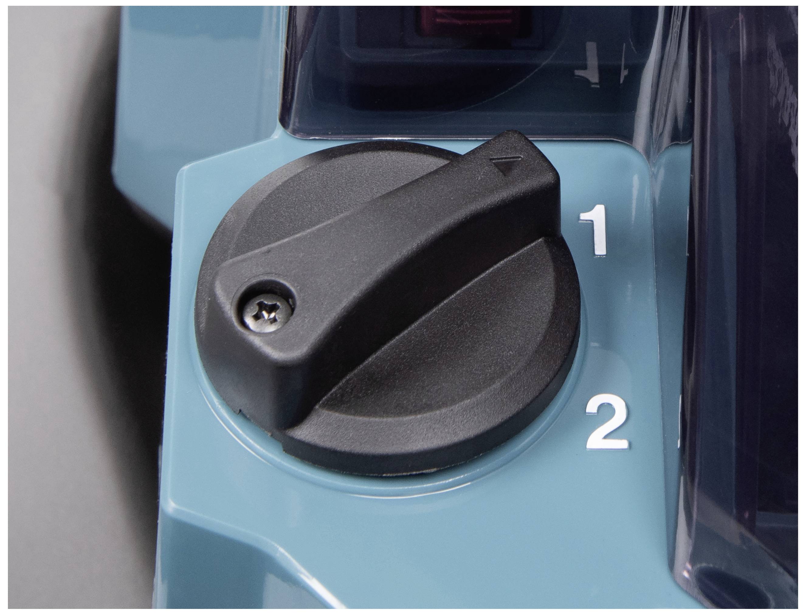 En sort drejekontakt på en maskine peger på positionen '2'. Til venstre herfor ligger positionen '1'.