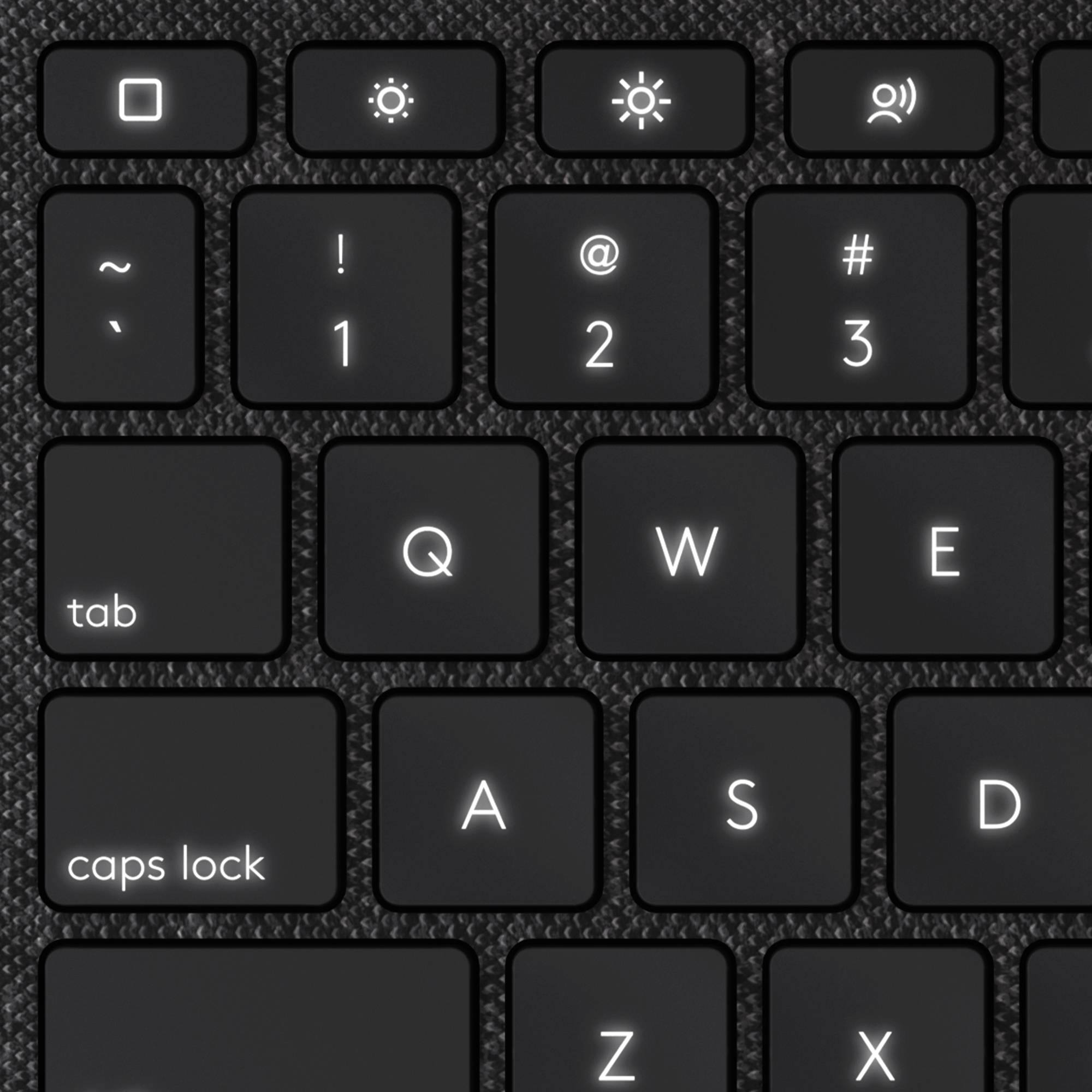 Sort computertastatur med baggrundsbelysning; viser taster for tabulator, caps lock og talrækken med specialtegn.
