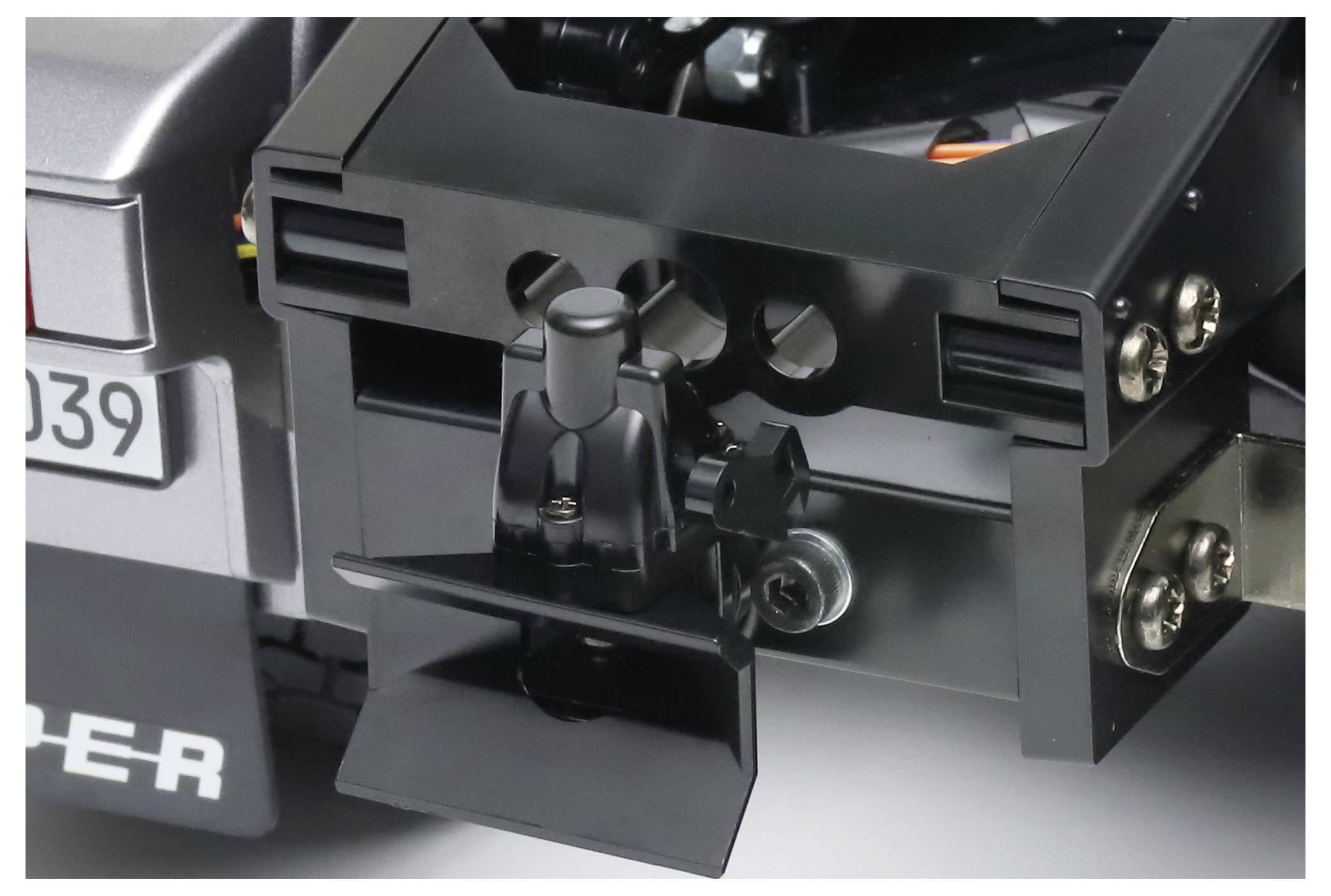 Nærbillede af et sort anhængerbeslag på et grå køretøj. I baggrunden ses dele af køretøjets bagende.